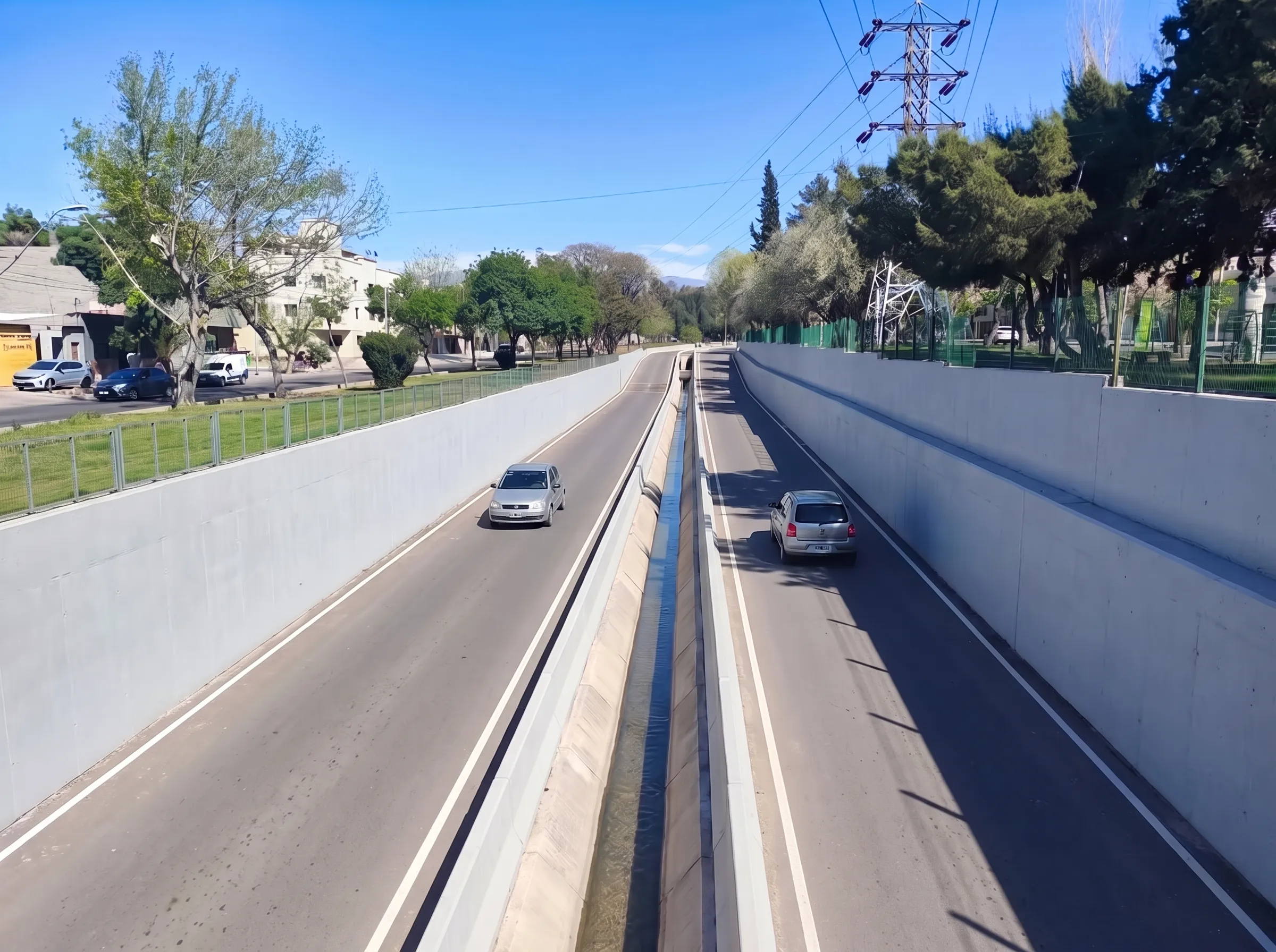 La propuesta vista hacia el oeste: dos carriles de asfalto, un canal angosto en el medio con defensas de hormigón y muros limpios